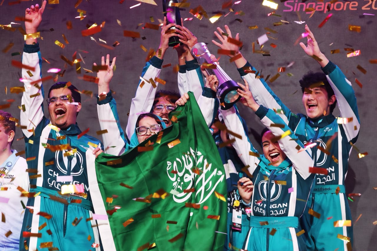 احتفال فريق LYNX Racing بالكأس والعلم السعودي وسط القصاصات الملونة في سنغافورة
